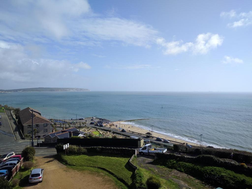 uma vista para uma praia com carros estacionados na areia em Mayfair Hotel - Isle of Wight em Shanklin