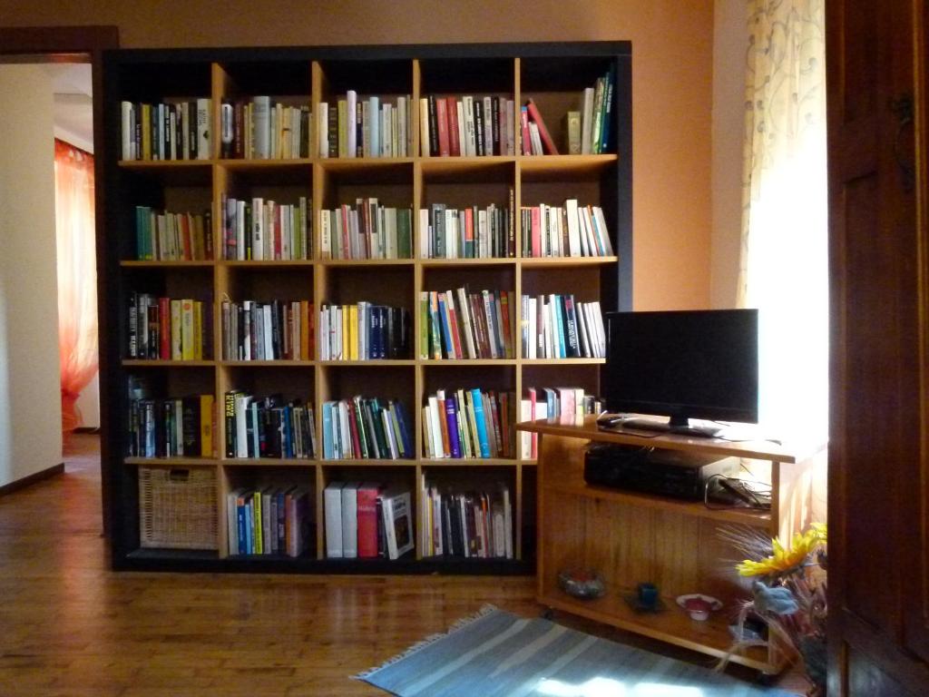 a book shelf full of books in a room at La Canàoula in Bobbio Pellice