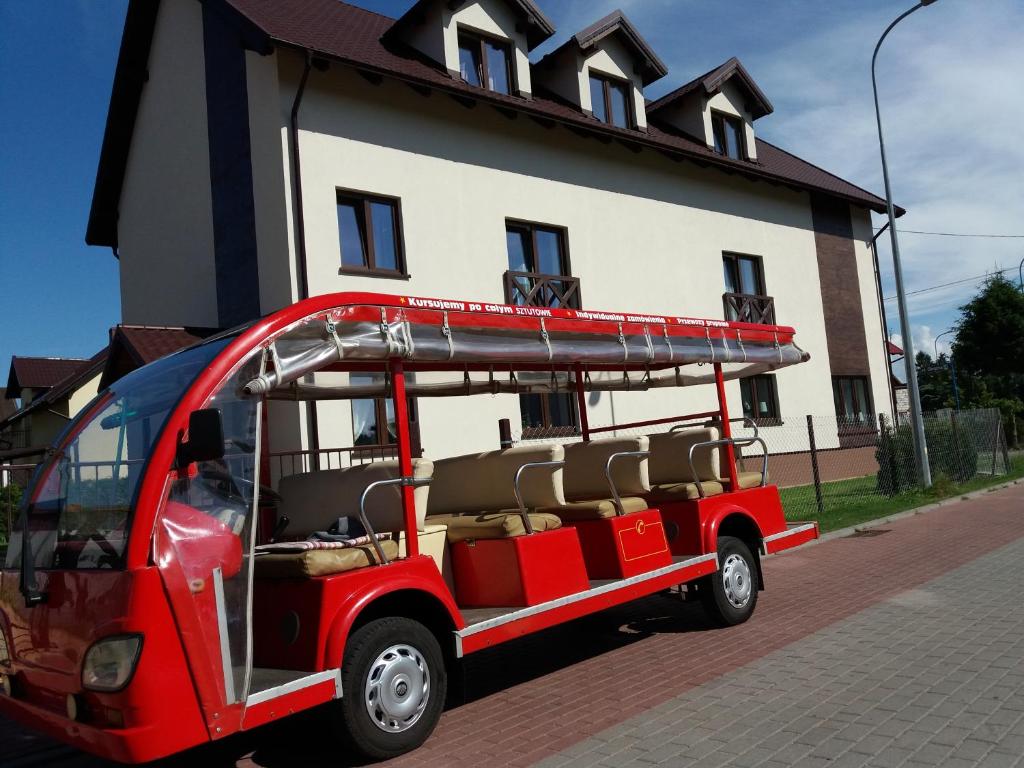 un golf cart rosso parcheggiato di fronte a una casa di Rodart Morski a Sztutowo