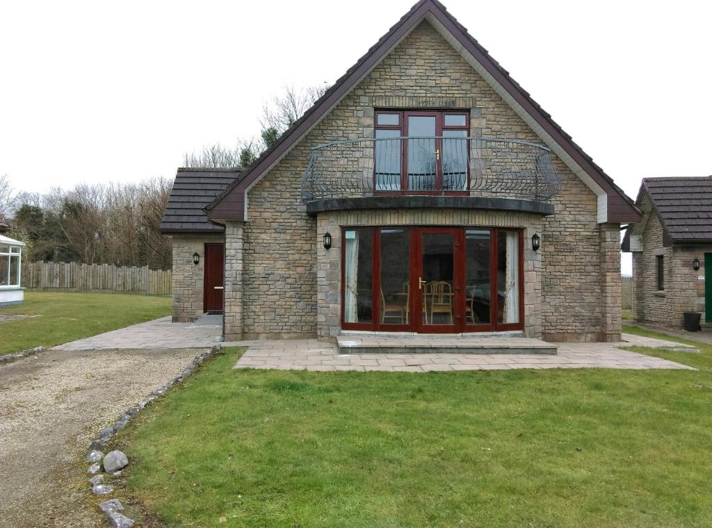 a brick house with red doors and a yard at Galway Bay Lodge in Oranmore