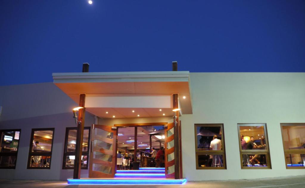 un frente de tienda con una luz azul delante en Hoey Moey Backpackers, en Coffs Harbour