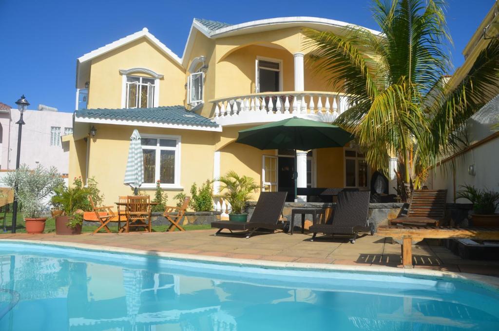 une maison avec une piscine devant une maison dans l'établissement Villa Sundara Mauritius, à Trou aux Biches