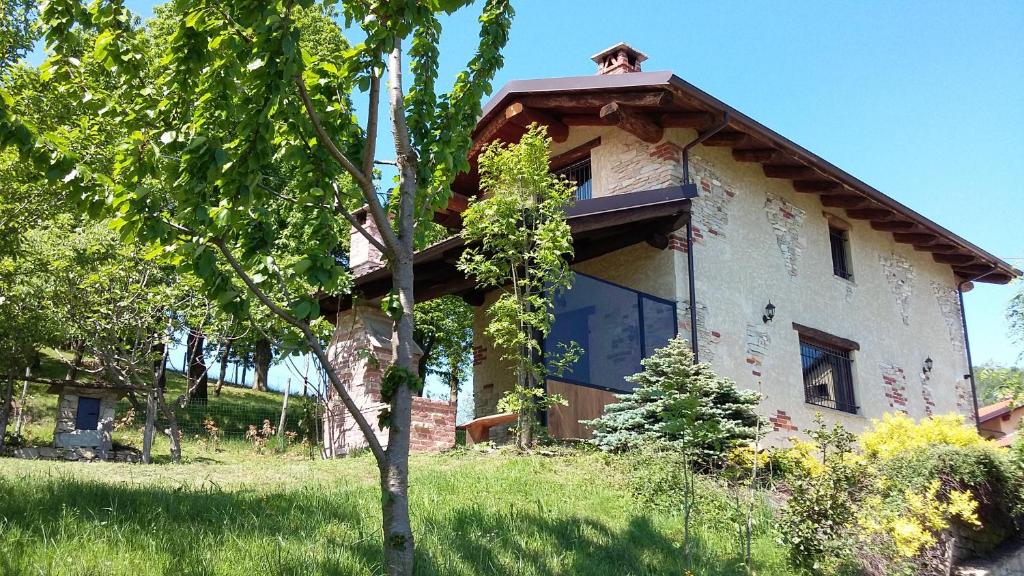 dom z drzewem przed nim w obiekcie Casa Vacanze Le Primule w mieście Peveragno