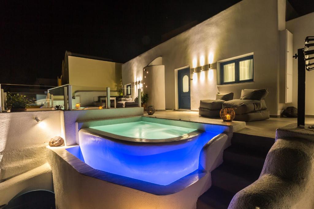 a jacuzzi tub in a living room at night at Amera Suites in Fira
