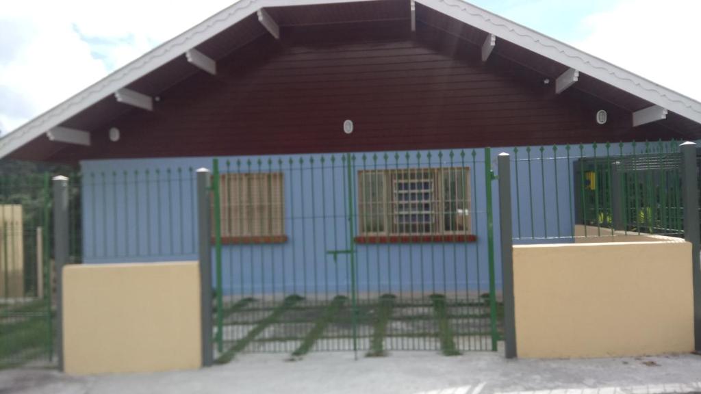 a blue building with a gate in front of it at Vista Bela in Campos do Jordão