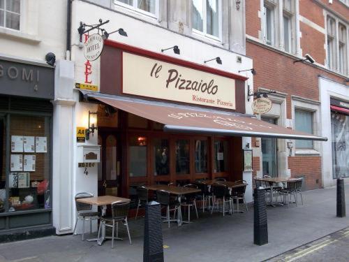 a restaurant with tables and chairs outside of a building at Mermaid Suite Hotel in London