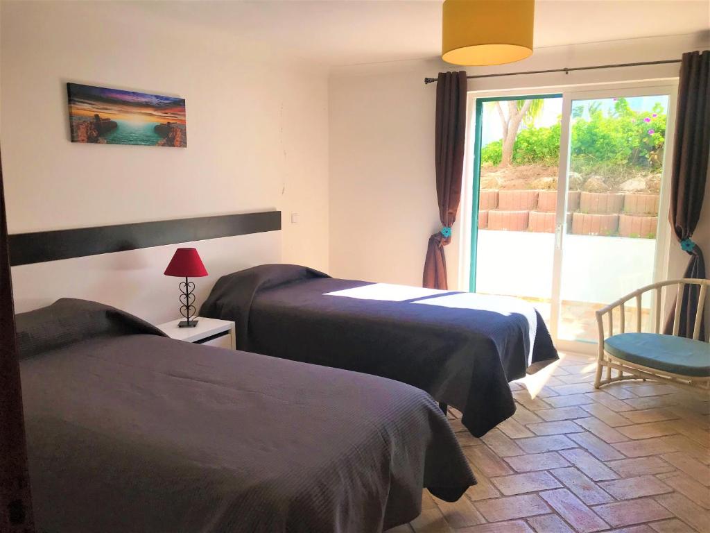 a hotel room with two beds and a window at Casas da Vila in Luz