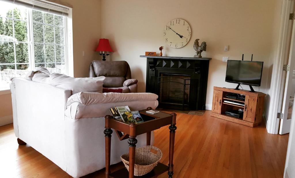un salon avec un canapé blanc et une télévision dans l'établissement Charming, Private Cottage in Myrtle Creek, à Myrtle Creek