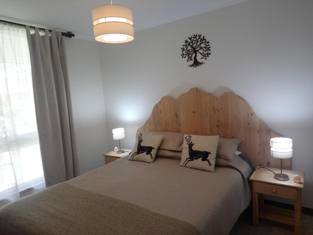 1 dormitorio con 1 cama grande y 2 almohadas para gatos en Departamento en Pucon, en Pucón