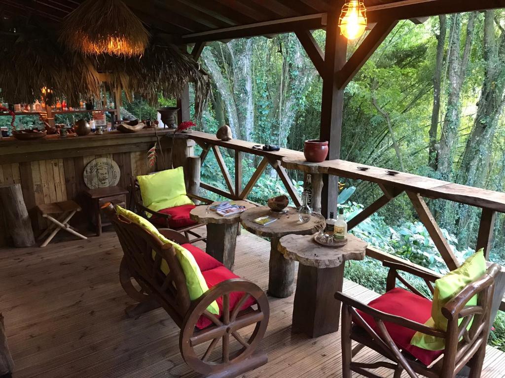 eine Veranda einer Hütte mit Stühlen und einem Tisch in der Unterkunft Martinique Treehouse in Canton Suisse