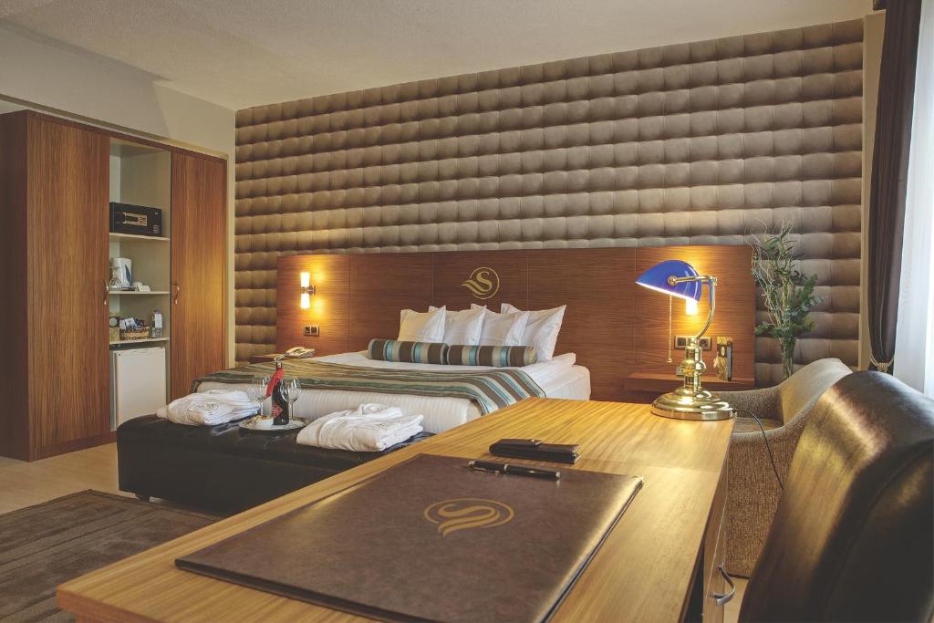 イズミールにあるススズル アトランティス ホテルのベッドとデスクが備わるホテルルームです。