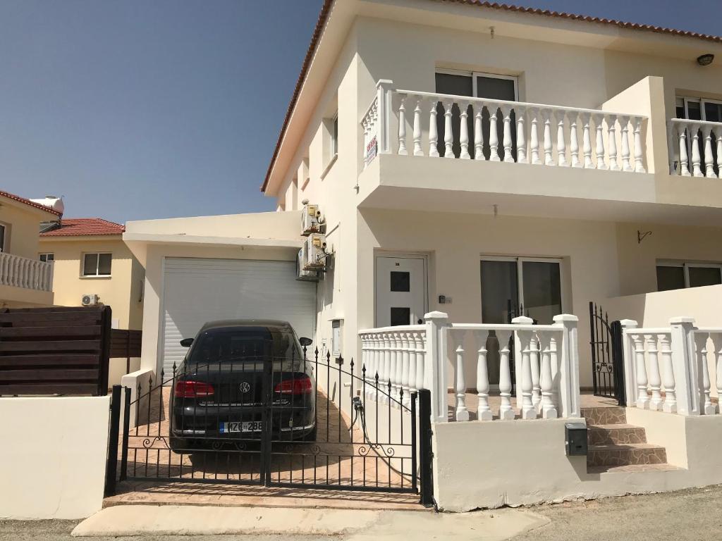 a car parked in front of a white house at Villa Nissi Beach 28 in Ayia Napa