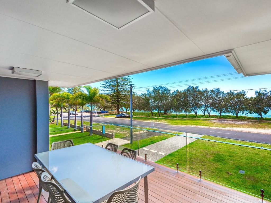 einen Balkon mit einem Tisch und Stühlen sowie Straßenblick in der Unterkunft NRMA Woodgate Beach Holiday Park in Woodgate