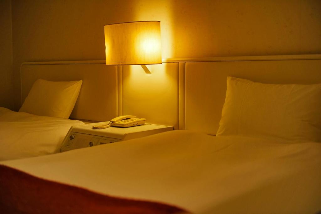 Postel nebo postele na pokoji v ubytování LiVEMAX Resort Atami Forest