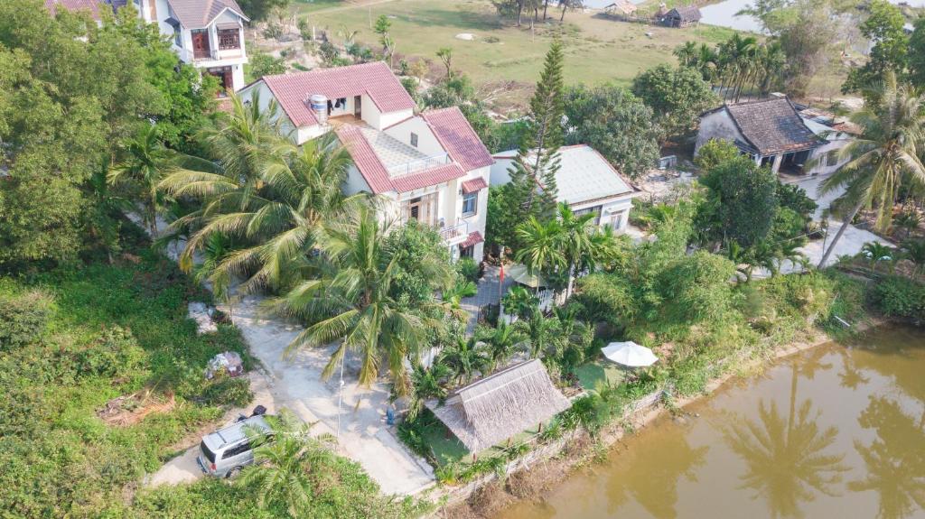 eine Luftansicht eines Hauses neben einem Fluss in der Unterkunft Tra Que Riverside Homestay in Hoi An