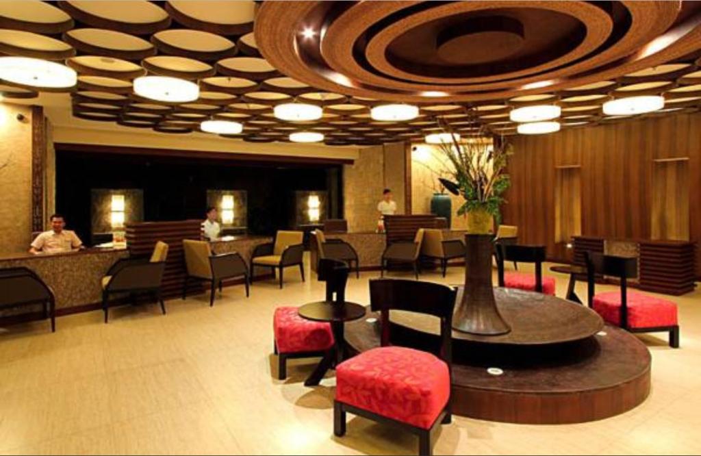 a hotel lobby with tables and chairs and a bar at The Bellevue Resort in Panglao Island