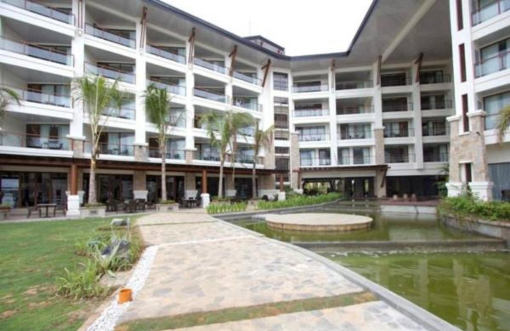 a large apartment building with a pond in front of it at The Bellevue Resort in Panglao Island