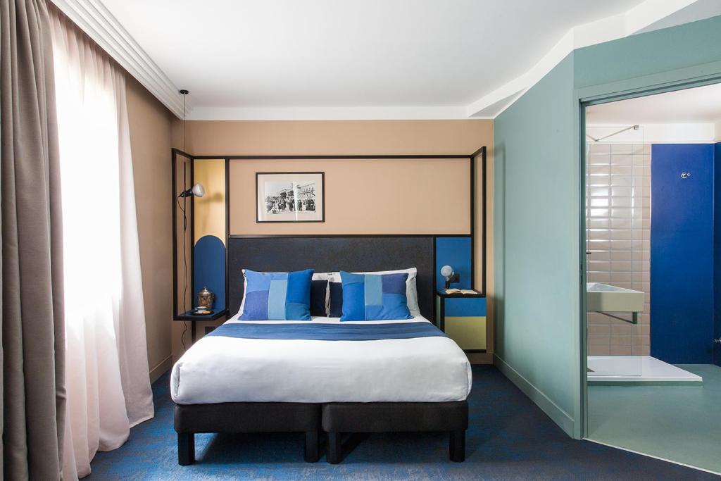 Кровать или кровати в номере Hôtel les Cigales