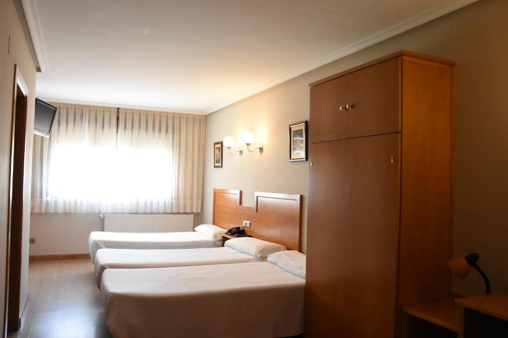 Postel nebo postele na pokoji v ubytování Hotel Carbayon