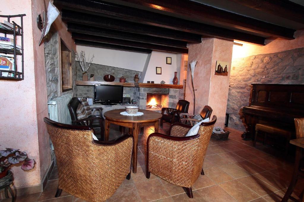 ein Esszimmer mit einem Tisch, Stühlen und einem Klavier in der Unterkunft El Pedrís in El Pont de Suert