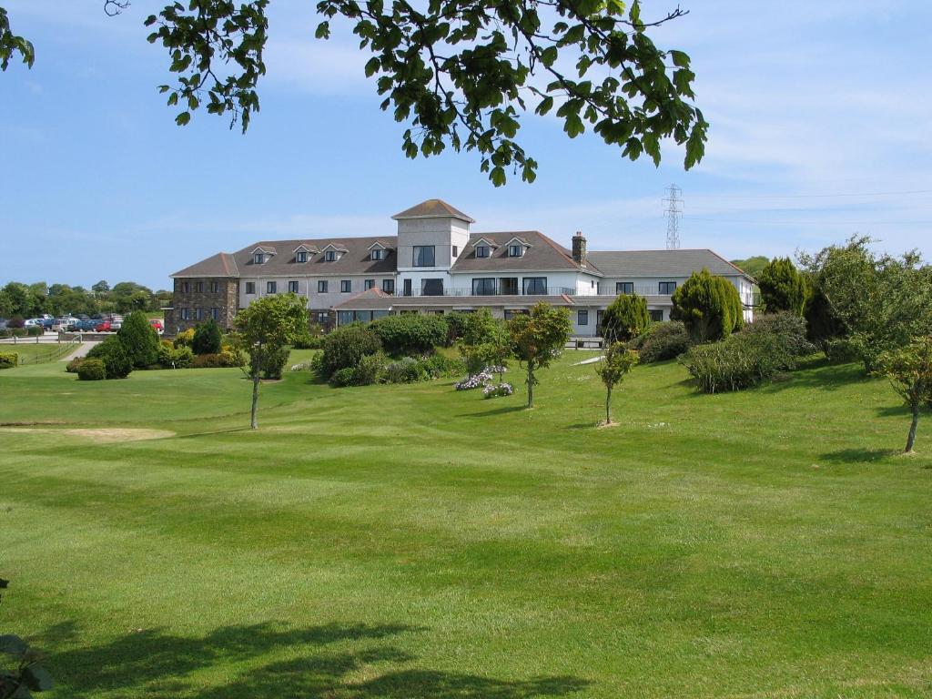 una casa grande en un campo verde con árboles en Bowood Park Hotel, en Camelford