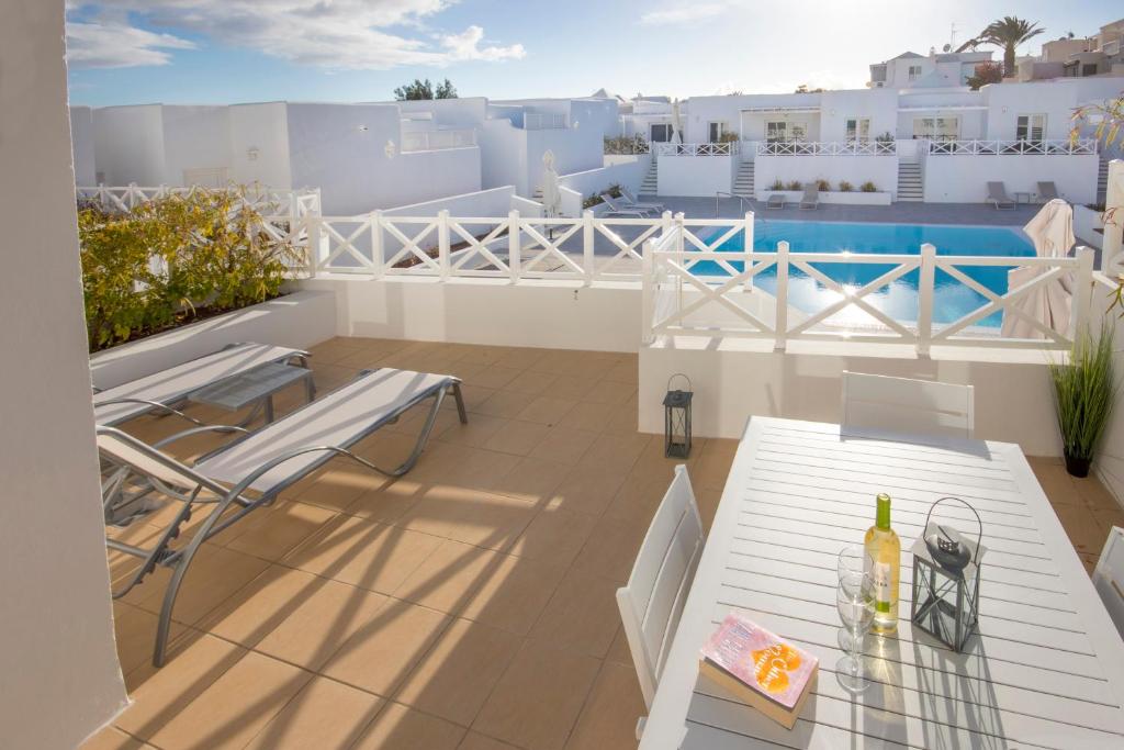 a patio with a table and chairs on a balcony at Flower Beach Lanzarote in Playa Honda