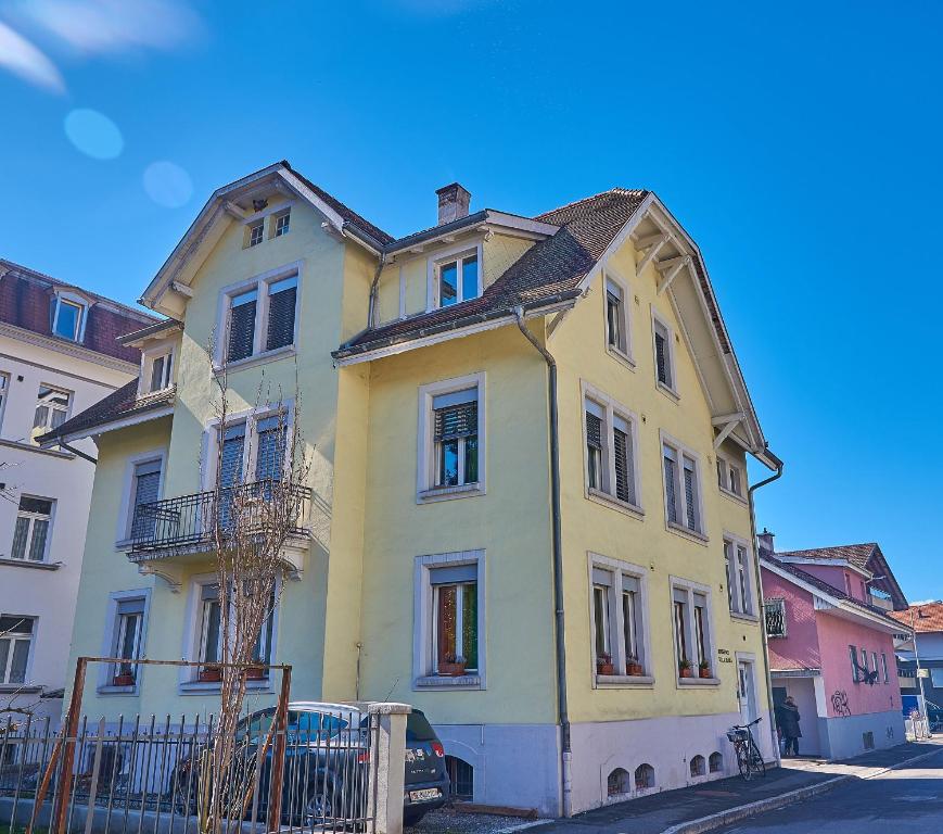 une maison jaune sur le côté d'une rue dans l'établissement Residence Villa Flora, à Interlaken
