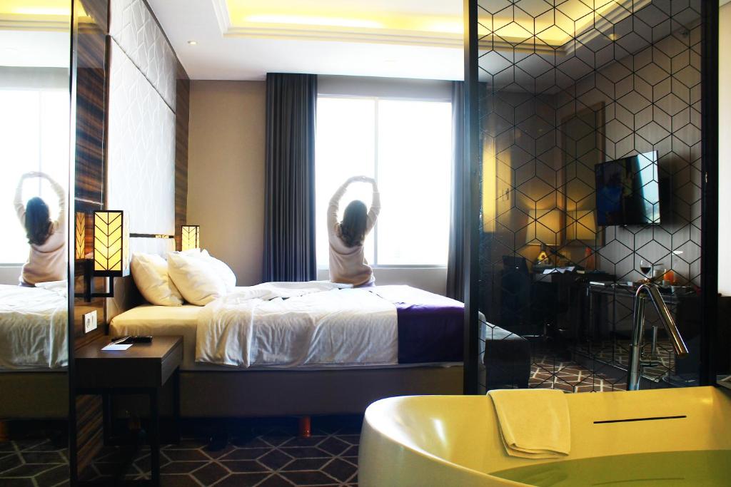 Postel nebo postele na pokoji v ubytování Swiss-Belinn Tunjungan Surabaya