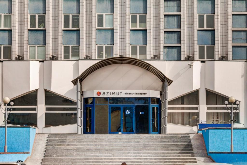a building with a blue door and stairs in front at AZIMUT Hotel Kemerovo in Kemerovo