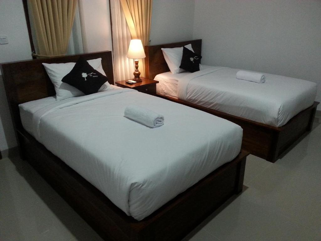 twee bedden naast elkaar in een kamer bij Ega Homestay in Nusa Penida