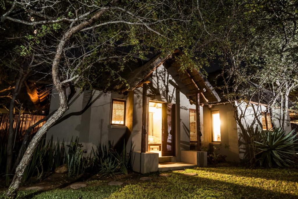 a small house with a porch at night at Hoedspruit Raptors Lodge N16 in Hoedspruit
