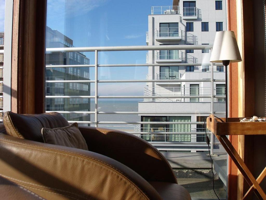 un soggiorno con divano e una grande finestra di Zonnig appartement a Nieuwpoort