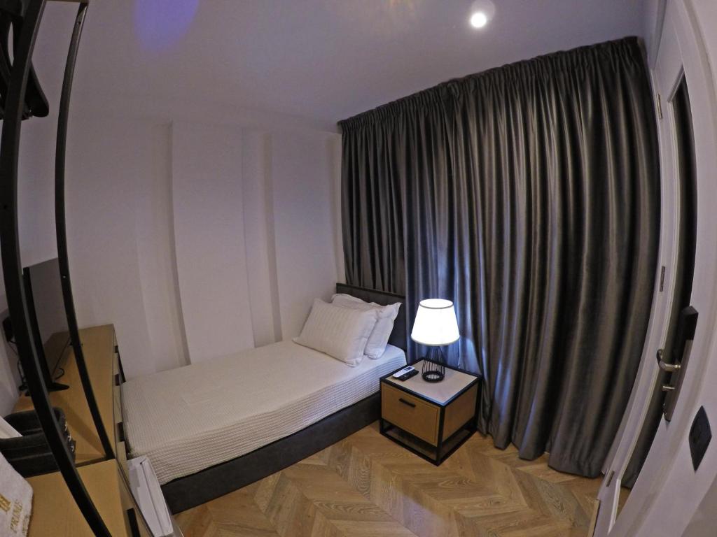 a small bedroom with a bed and a window at Prime Hotel in Tirana