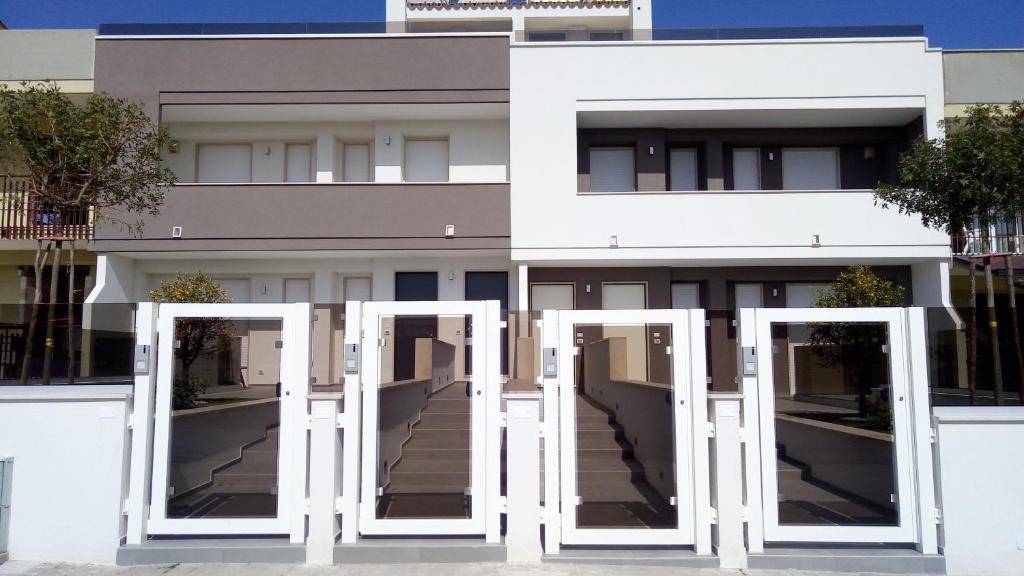 Manolo Case Vacanza في مونوبولي: مبنى ابيض ابوابه بيضاء امامه