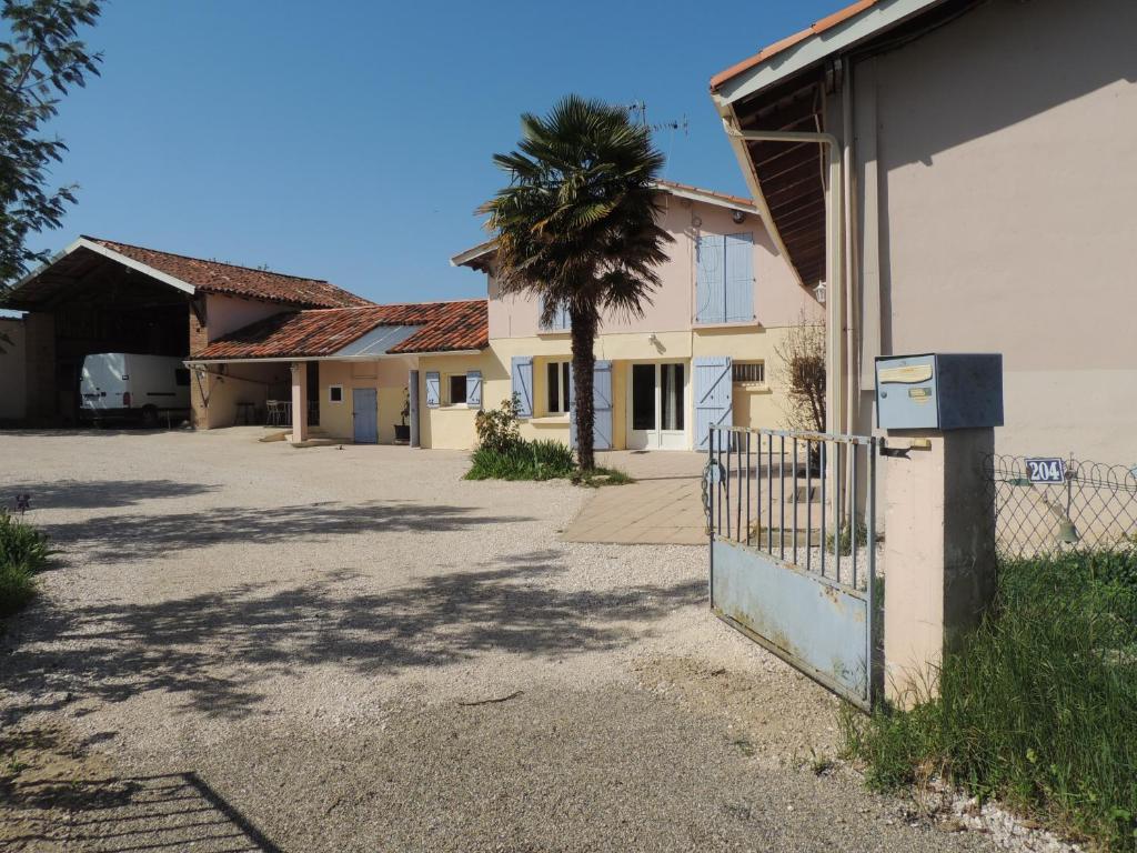 a building with a gate and a palm tree at La Maison de l'Ormeau in Montauban