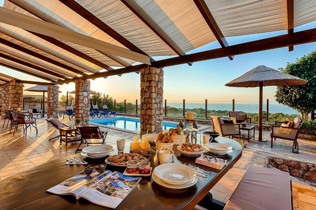 a table with food on it on a patio with a pool at Butterfly Villa in Theologos