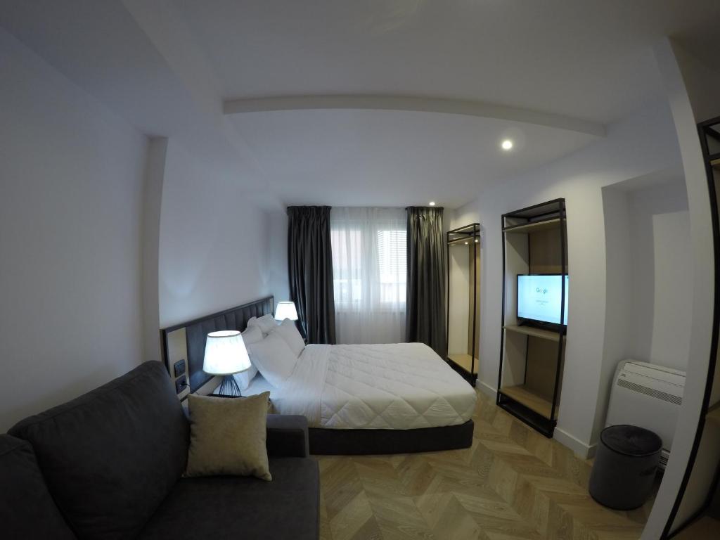 a hotel room with a bed and a couch at Prime Hotel in Tirana