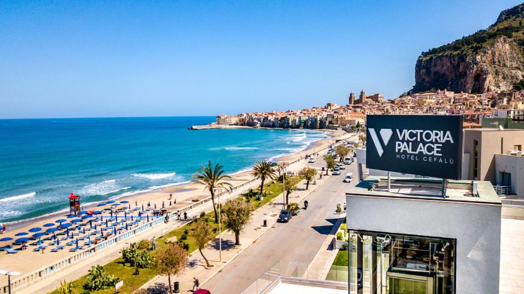 uma vista para a praia e para o oceano em Victoria Palace Cefalù em Cefalù