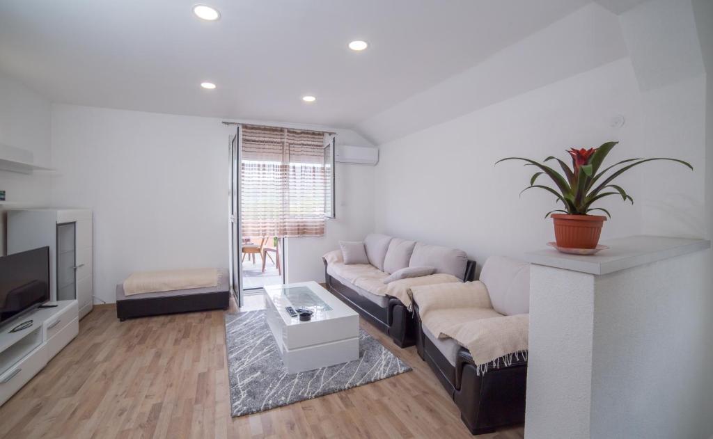 a living room with a couch and a tv at Apartment Milena in Virpazar