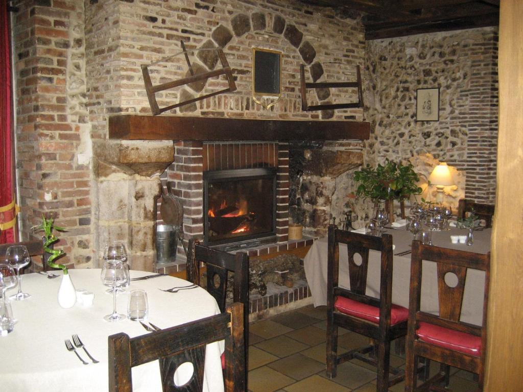 a restaurant with a fireplace in a stone wall at Logis Hotel Restaurant Le Cheval Blanc in Charny