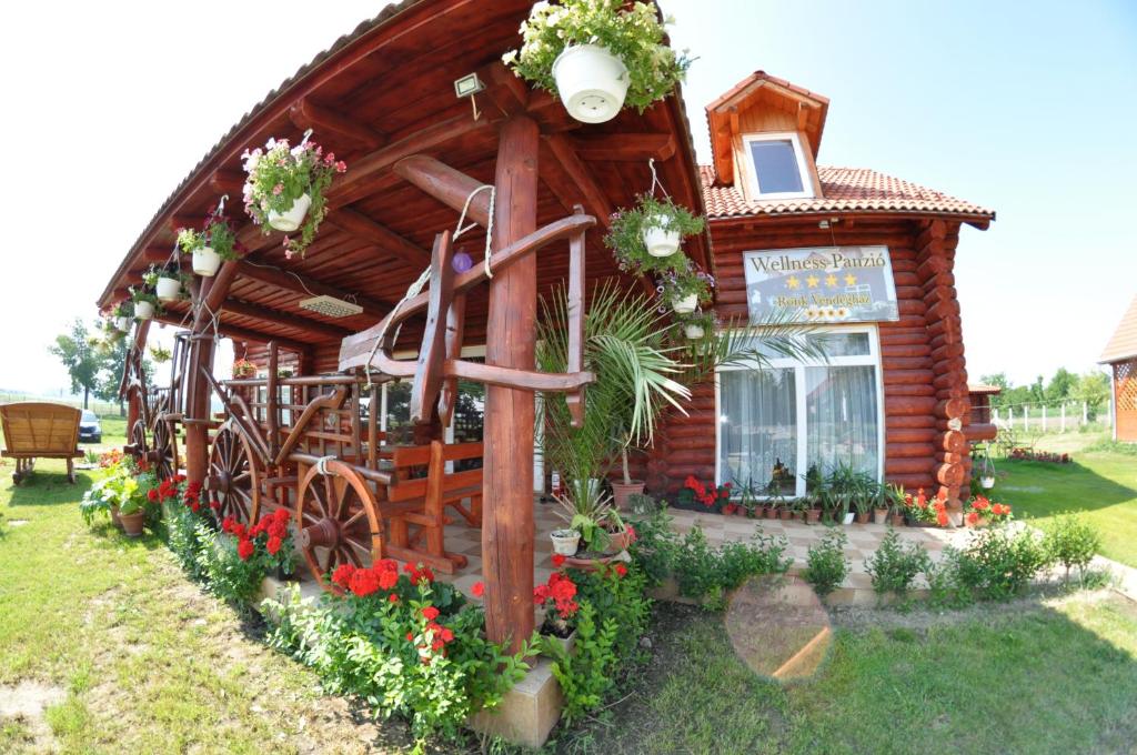 a small log cabin with a sign on it at Rönk-wellness Panzió Mezőpeterd in Mezőpeterd