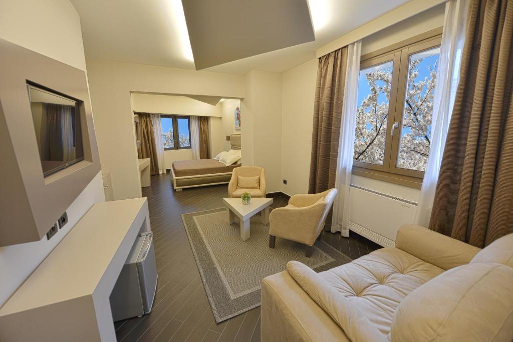 a hotel room with a couch, coffee table and a television at Petit Hotel Elita in Shkodër