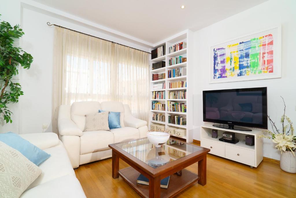 a living room with a white couch and a tv at Vivaldi Valencia in Valencia