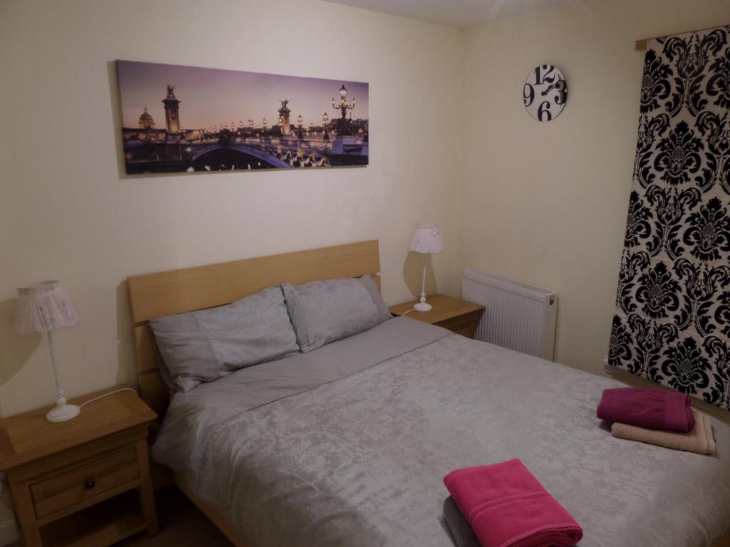 a bedroom with a bed with pink towels on it at Church Street Apartments in Inverness