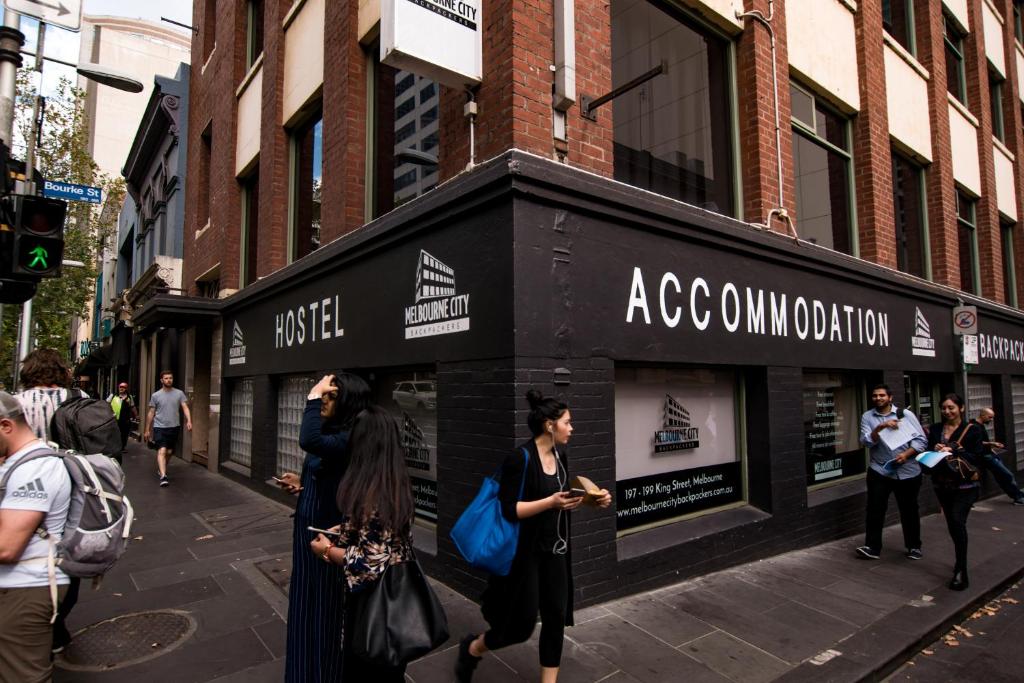 a group of people walking down a city street at Melbourne City Backpackers in Melbourne