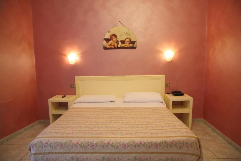 a bedroom with a bed with two night stands and two lights at Hotel PRINCIPE AMEDEO in Rome
