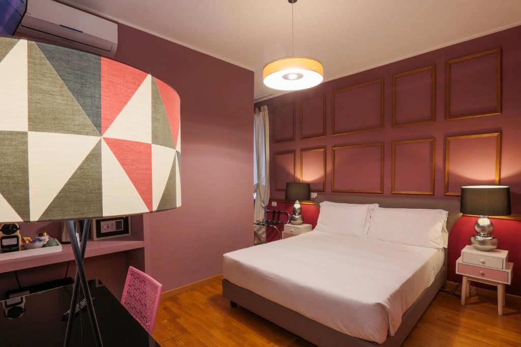 ein Schlafzimmer mit einem großen Bett und einer Lampe in der Unterkunft DEM Hotel in Rom