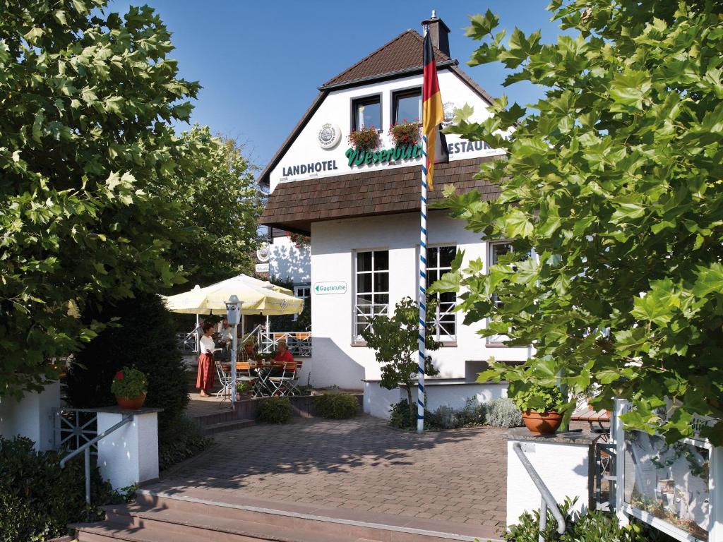 a building with a flag on top of it at Landhotel Weserblick in Beverungen