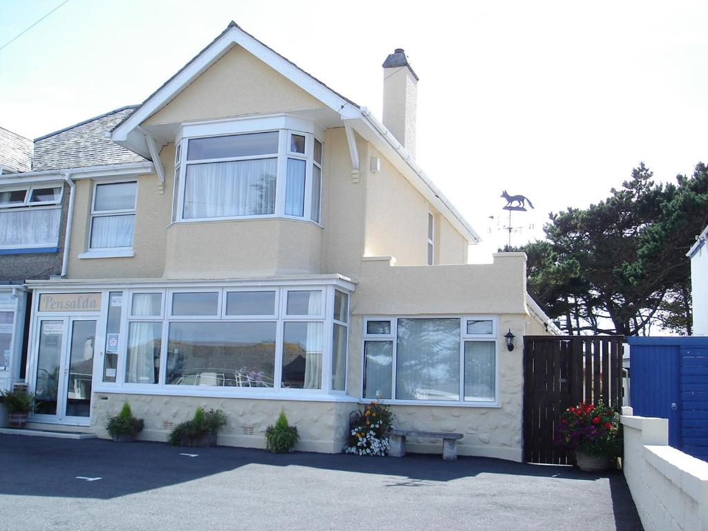 a house with white windows and a blue gate at Pensalda Guest House in Newquay