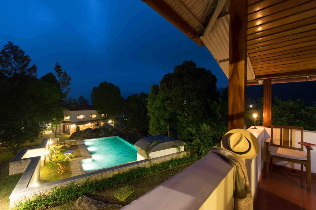 a backyard with a swimming pool at night at Windermere Estate in Munnar